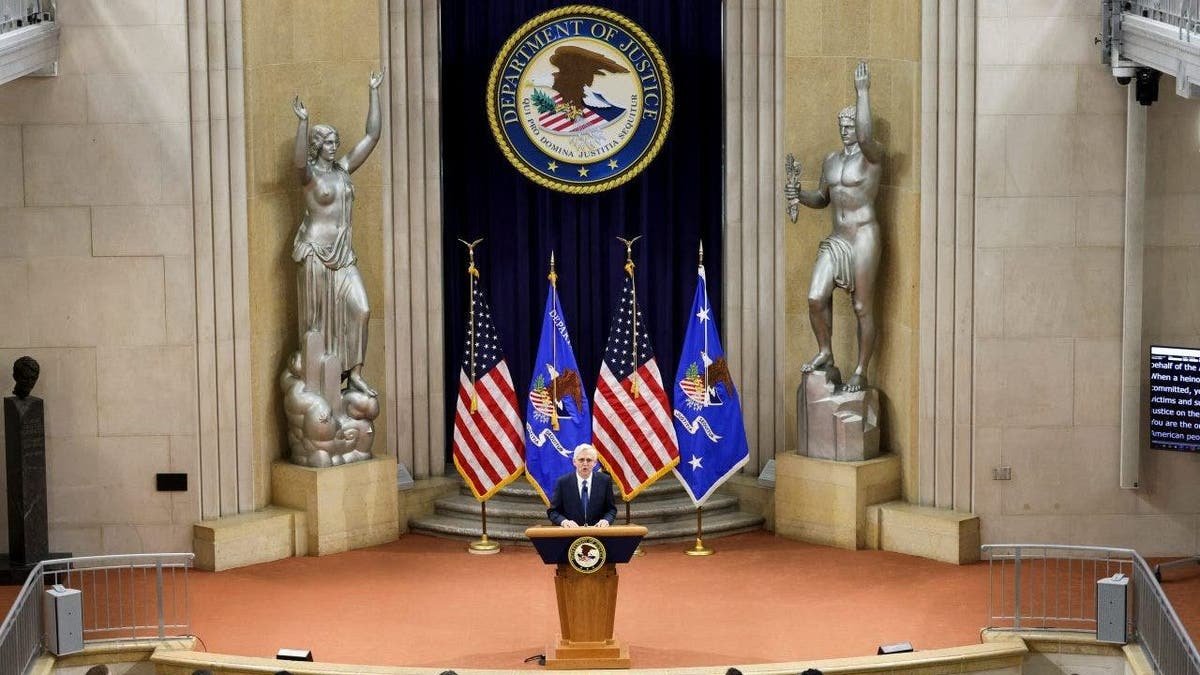 Merrick Garland speaking at a podium inside the Department of Justice in Washington, D.C.
