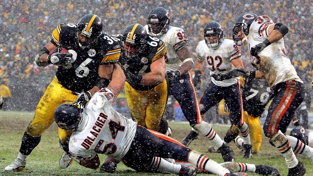 Jerome Bettis of the Pittsburgh Steelers running with the football over Brian Urlacher of the Chicago Bears at Heinz Field.