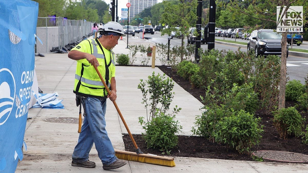 Worker performing landscaping work outside the Obama Presidential Center.
