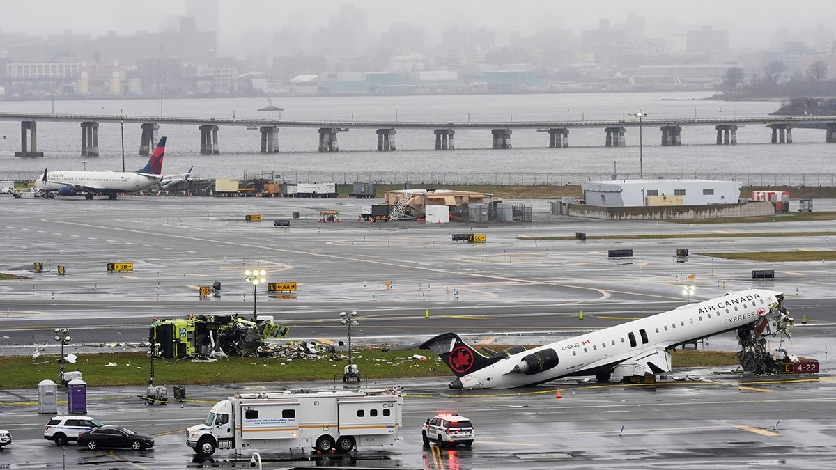 An Air Canada jet and Port Authority fire truck parked on the runway at LaGuardia Airport