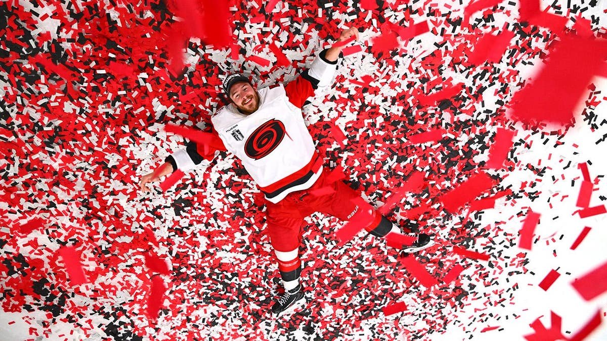 Andrei Svechnikov of the Carolina Hurricanes posing on ice with confetti