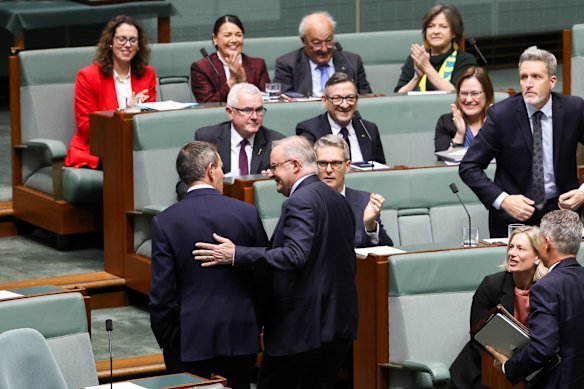 Treasurer Jim Chalmers and Prime Minister Anthony Albanese leave the House of Representatives to applause from Labor MPs after the tax laws passed on Thursday.