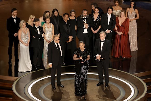 Christopher Nolan with wife and producer Emma Thomas accepting the Best Picture Academy Award in front of the Oppenheimer cast at the 2024 ceremony.