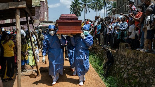 Health workers carry a coffin with the body of Reverend Sylvestre Atama who died from Ebola in the DRC.