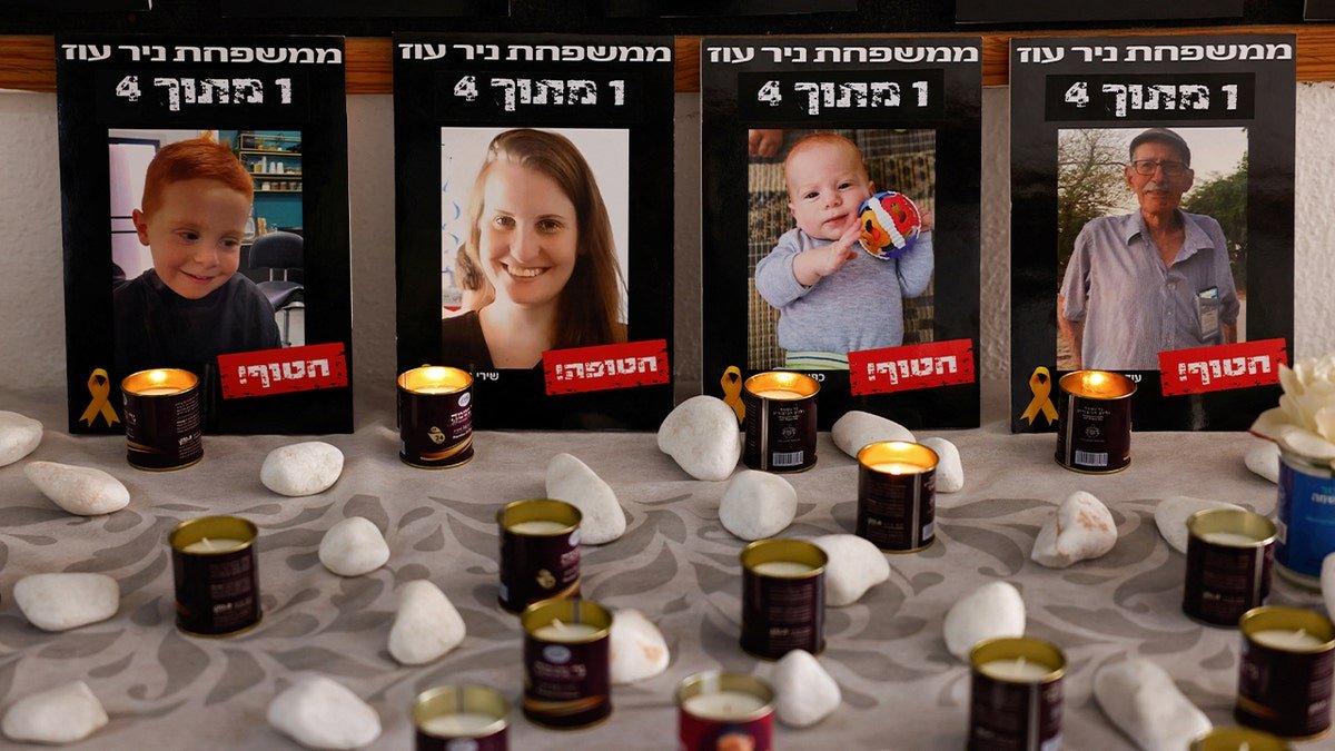 Photos of the Bibas family and Oded Lifshitz displayed next to candles in a dining room