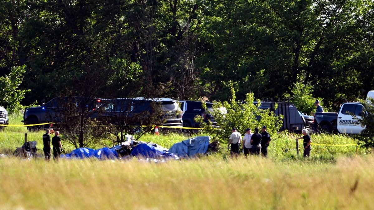 Emergency personnel investigating plane crash site at Butler Memorial Airport in Butler, Mo.