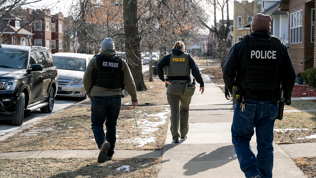 Federal ICE police officers patrolling a suburban street in Chicago.
