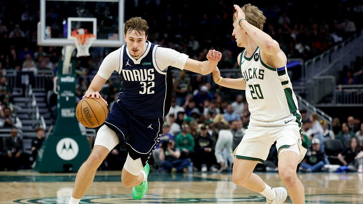 Dallas Mavericks forward Cooper Flagg drives against Milwaukee Bucks guard AJ Green during a basketball game