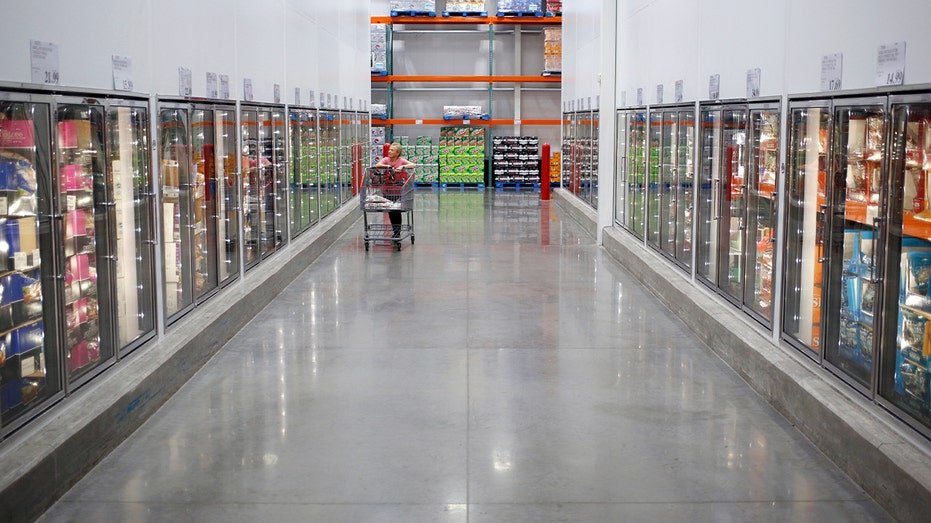 shopper walking through costco fridge aisle