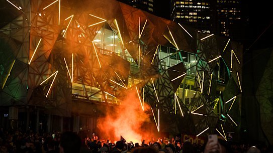 Soccer fans celebrate with a flare at Federation Square during the Matildas vs Denmark World Cup match.