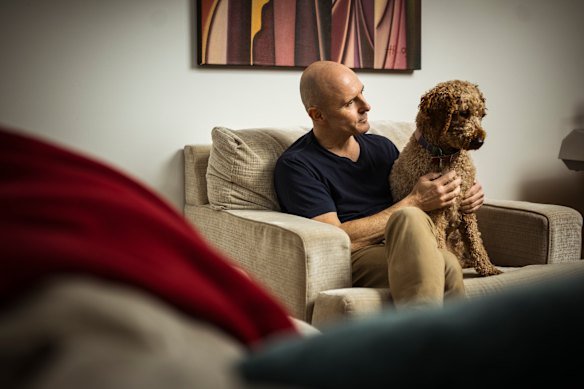 Trew, pictured at home with his dog Bonnie, initially dismissed his chest pain as reflux.