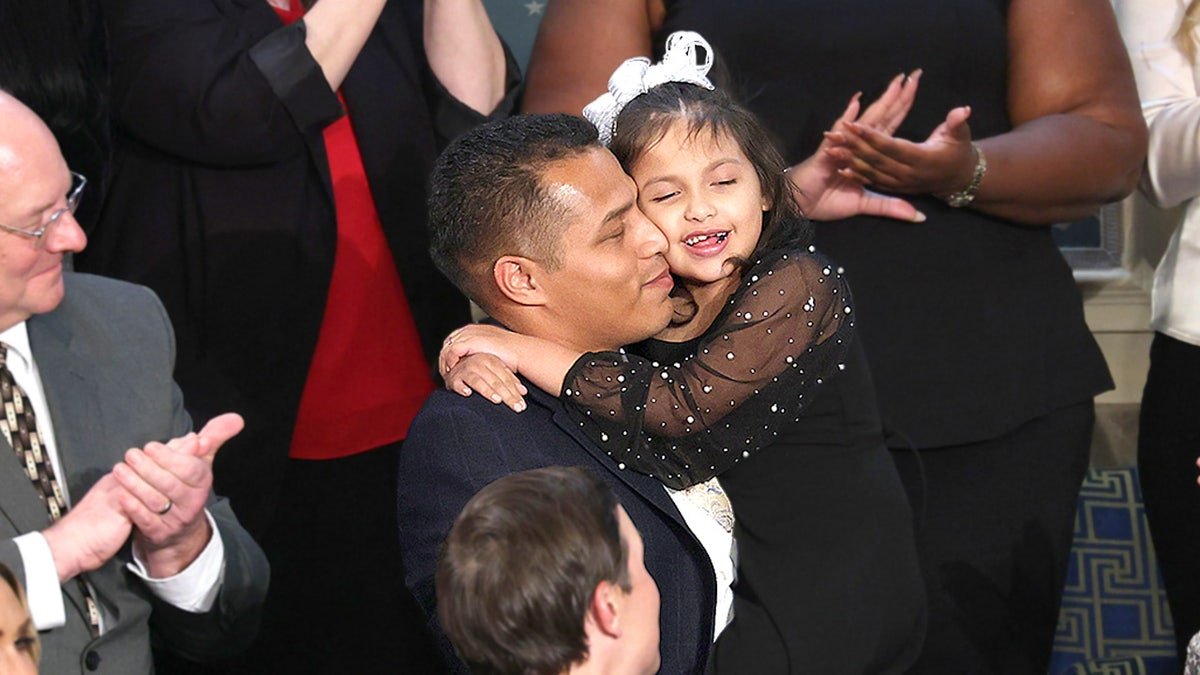 Marcus Coleman holds his daughter Dalilah Coleman during State of the Union address at U.S. Capitol