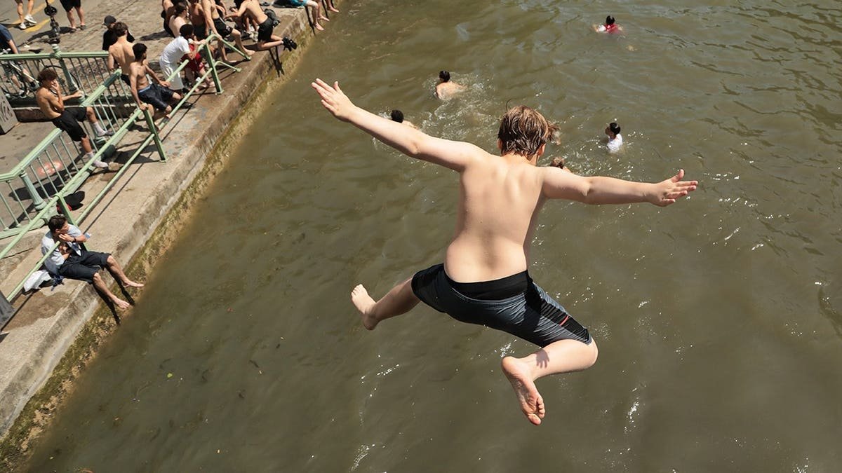 People swimming in Canal Saint-Martin in Paris to cool off during heatwave