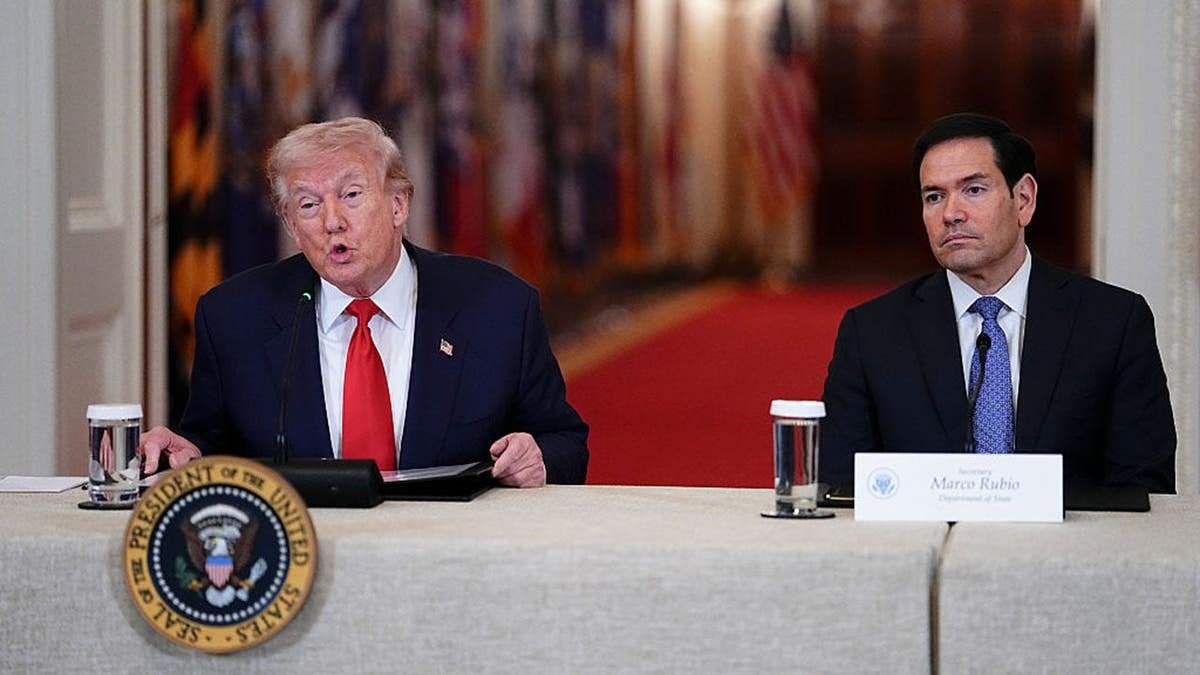 President Donald Trump and Secretary of State Marco Rubio seated during a roundtable in the White House East Room