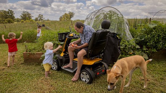 Peter Riley at home in Razorback with his grandchildren, Samson, 1, Noah, 3, and Abigail, 5, and family dog Atticus earlier this year, before his move into palliative care.