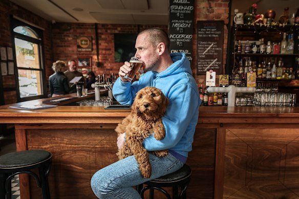 The Rose Hotel’s owner, Neil Spark, with his dog, Bailey. The City of Yarra threatened Spark with a fine for having dogs inside the pub. 