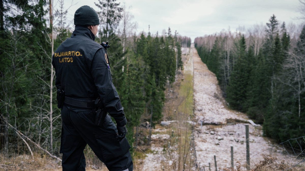 Senior border guard officer Juho Pellinen looking at fence marking Finland Russia border near Pelkola crossing