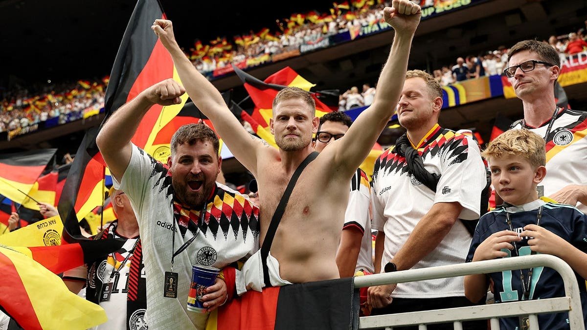 Germany fans seated in the stands at a stadium.