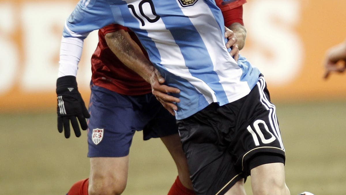 Lionel Messi tangles with Jay DeMerit back on March 26, 2011 in East Rutherford, New Jersey. (Jeff Zelevansky/Getty Images)