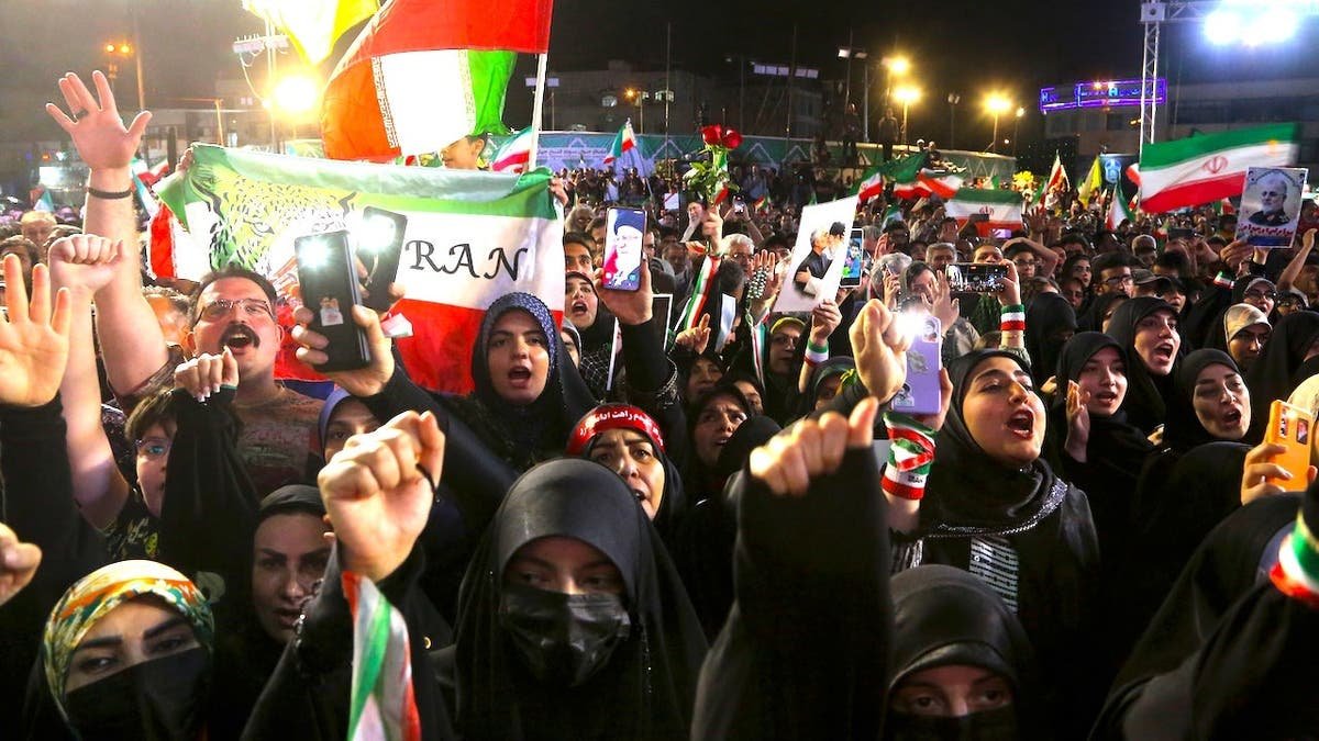 Iranian football supporters gathering at Enghelab Square in Tehran during a ceremony