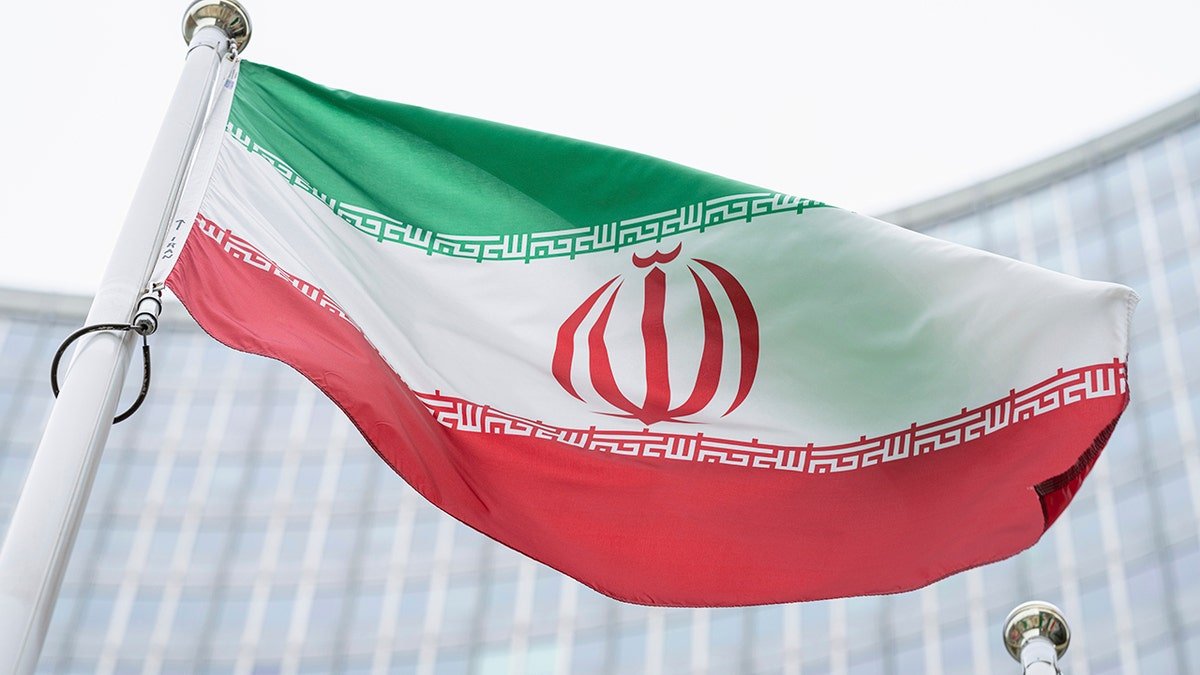 The flag of Iran waving in front of the International Atomic Energy Agency building in Vienna