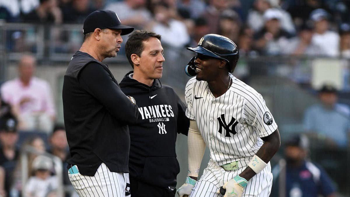 New York Yankees second baseman Jazz Chisholm Jr. receiving medical attention on his lower leg at Yankee Stadium.