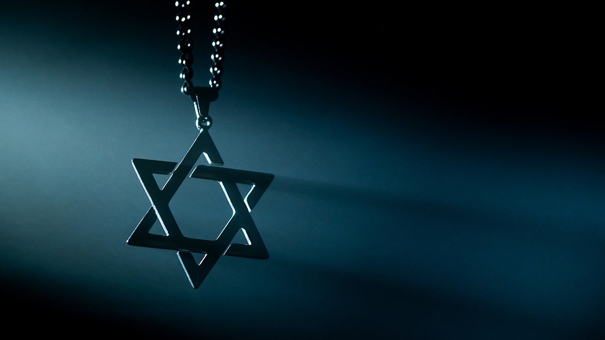 Star of David necklace over dark background