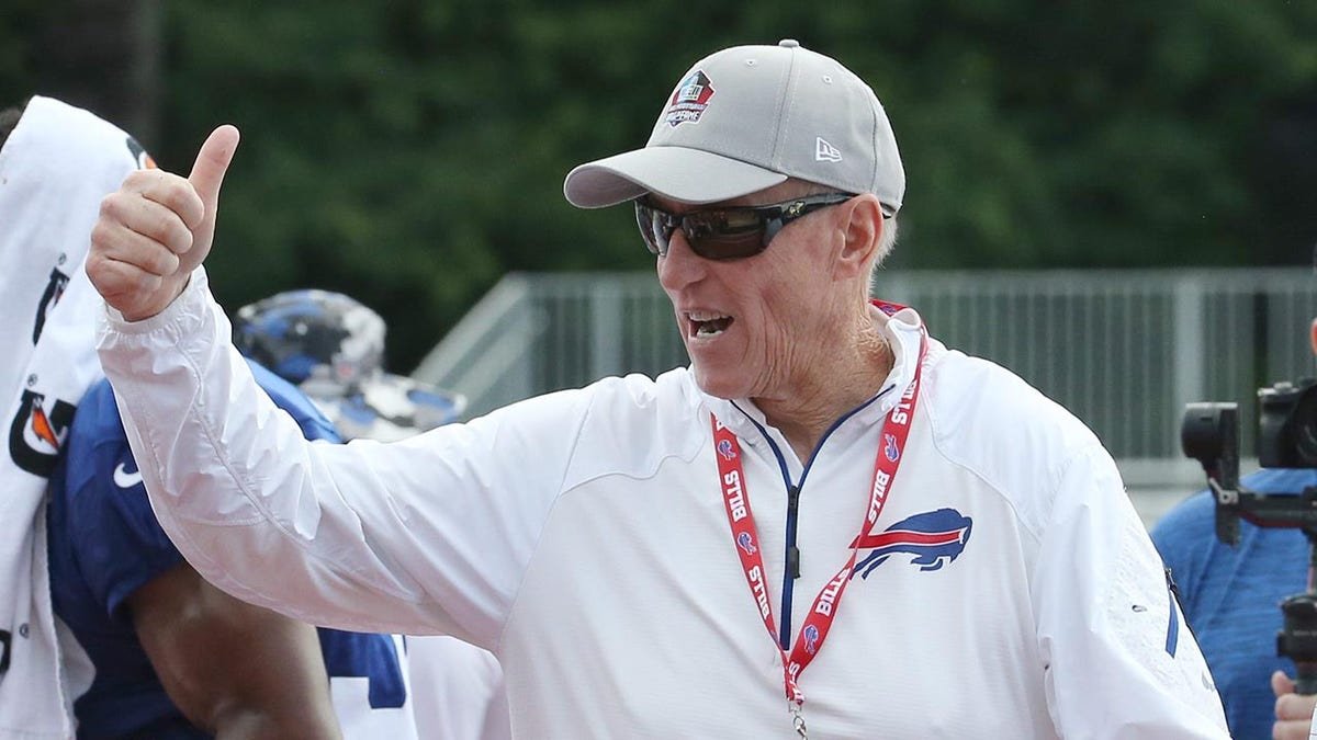 Former Bills quarterback Jim Kelly waving to crowd while leaving field at training camp