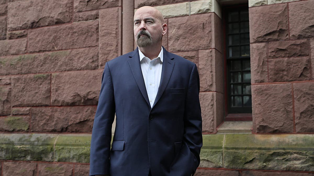 John Deaton posing for a portrait in Woburn, Massachusetts.