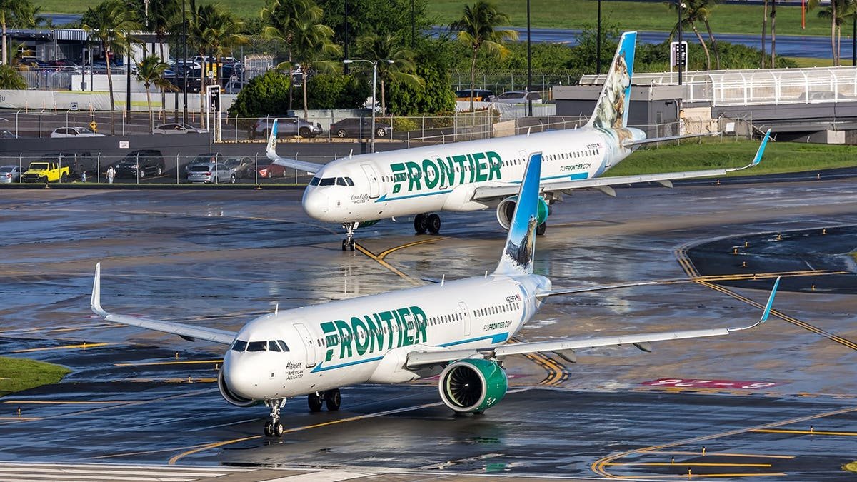 Juan Gabriel Reyes being restrained by passengers inside a Frontier airplane cabin