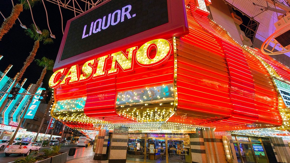 Large neon casino and liquor sign lit up at night on Fremont Street in Las Vegas