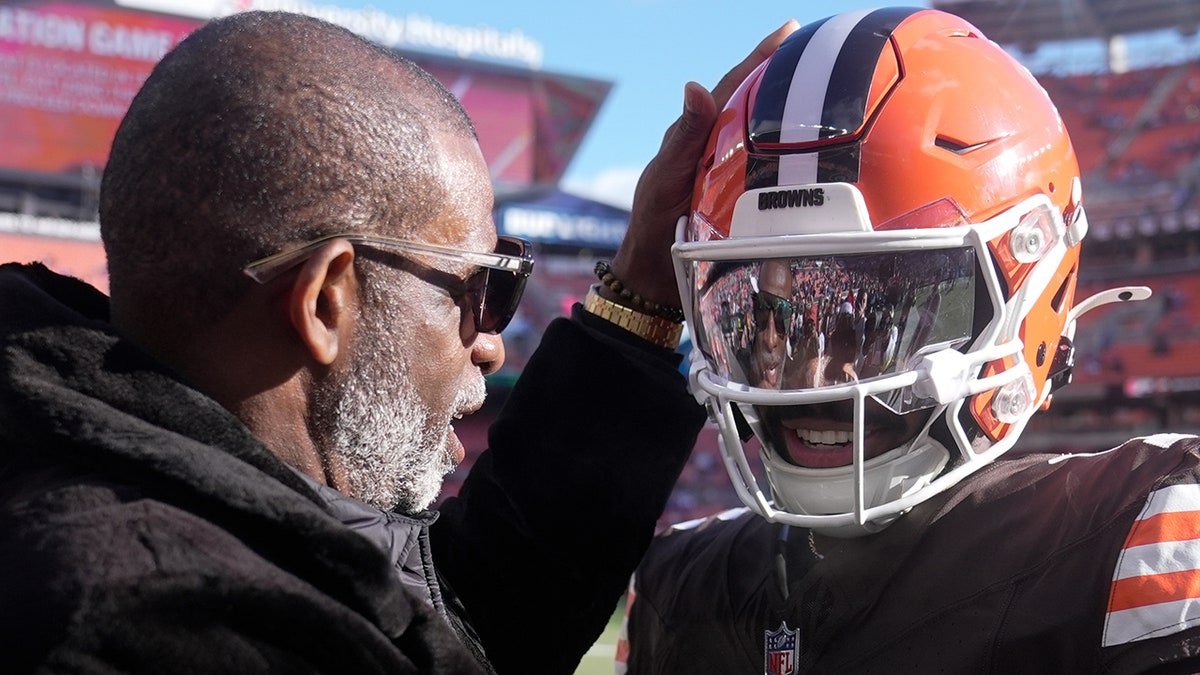 Cleveland Browns quarterback Shedeur Sanders greeting his dad Deion Sanders on the field