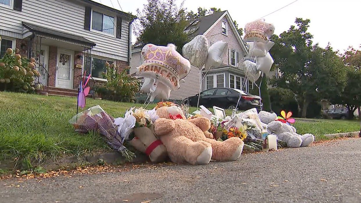 A memorial set up for Maria Niotis and Isabella Salas with flowers and candles.