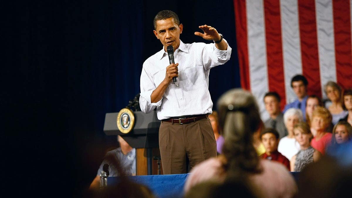 President Barack Obama answering a question during a health care town hall meeting in a gymnasium.