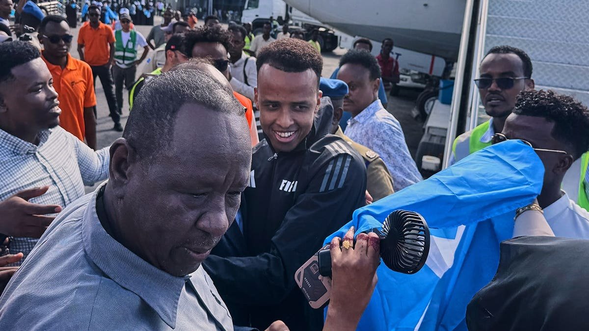 Referee Omar Artan standing with supporters in Mogadishu, Somalia