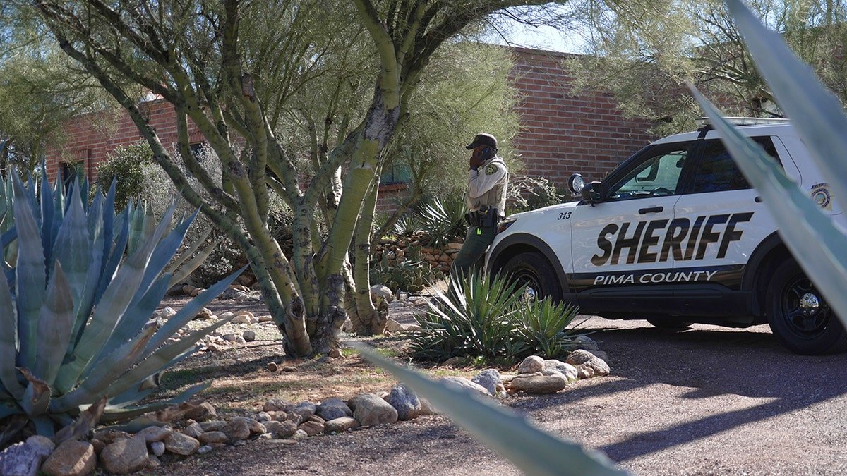 Pima County sheriff's official standing outside Nancy Guthrie's home in Tucson