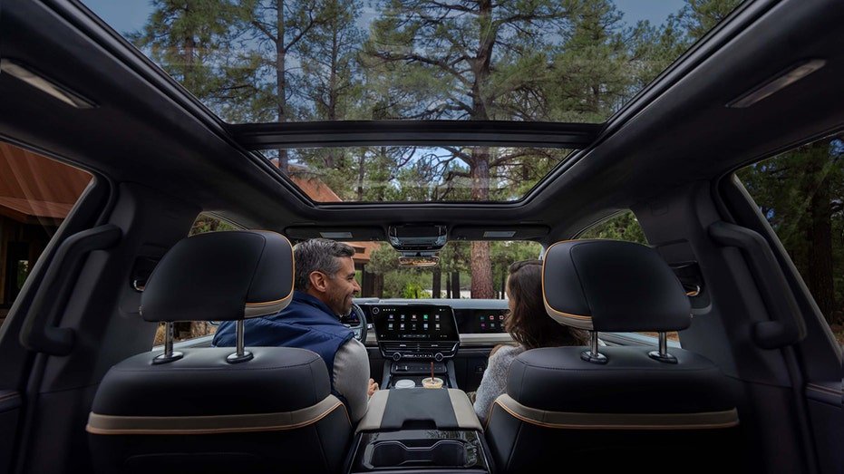 The second-row interior of a 2027 Chevrolet Silverado 1500 High Country features Enoki trim and a panoramic sunroof.