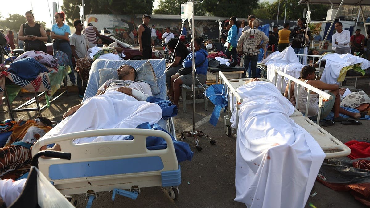 Patients lying on stretchers outside a hospital damaged by an earthquake in Catia La Mar, Venezuela