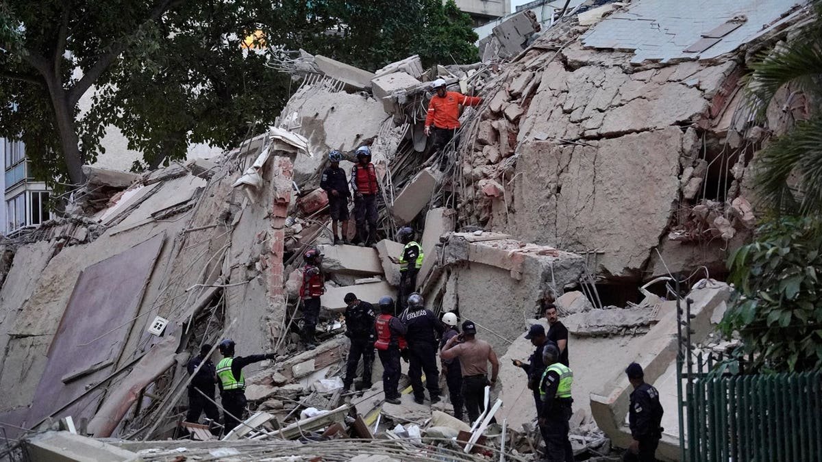 Rescuers search for victims in a collapsed building