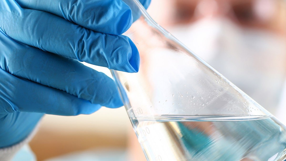 Male scientist holding empty vials in arm in laboratory setting