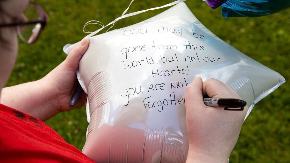 Kristan Newell writing messages on balloons at Lazybrook Park in Tunkhannock, Pennsylvania