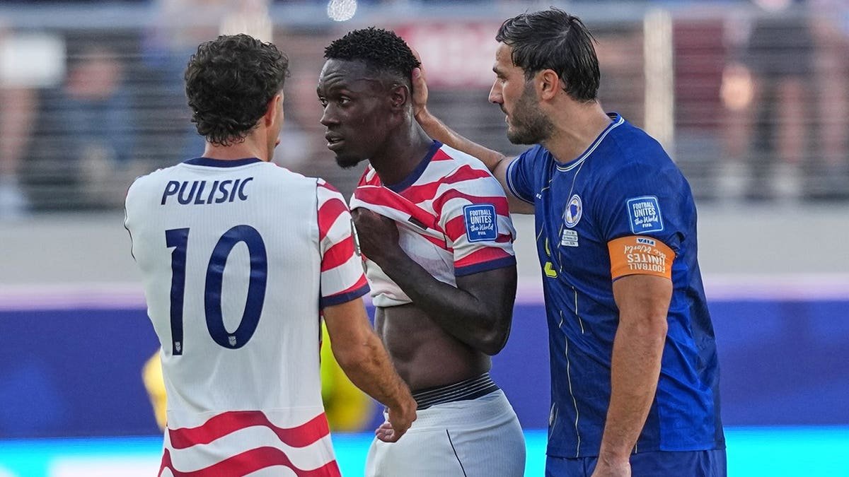Bosnia's Sead Kolasinac talks to USA's Folarin Balogun after ejection as Christian Pulisic watches.