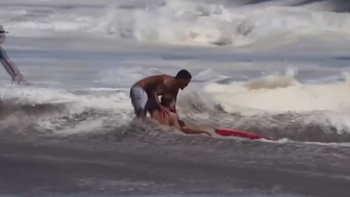 man pulls lifeguard holding kid