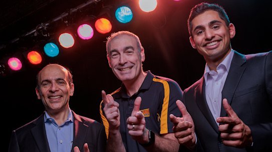 Former Wiggle Greg Page, Pramesh Kovoor and Joshua Kovoor on the stage at the Castle Hill RSL where Greg suffered a near-fatal cardiac arrest. 