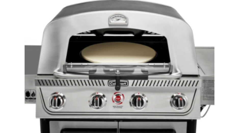 Close-up of a stainless steel gas grill with the lid open, revealing a pizza stone inside the cooking chamber.