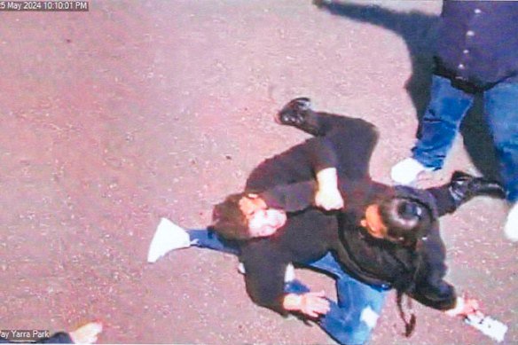Ebony Bell, wearing a black jumper and blue jeans, grapples with another person during the incident.