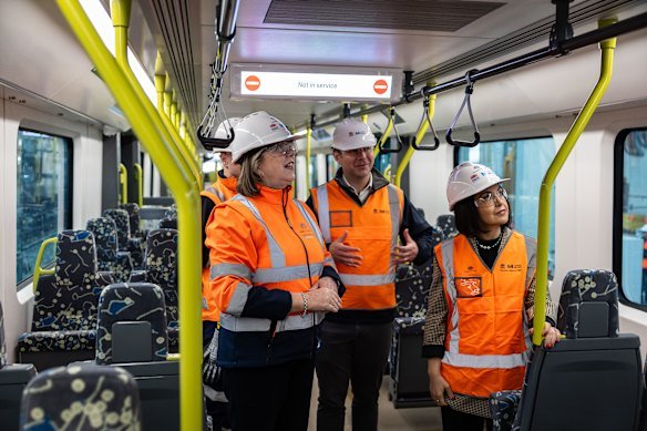 Federal Transport Minister Catherine King, left, Sydney Metro acting chief executive Hugh Lawson and NSW Deputy Premier Prue Car inspect the first airport metro train.