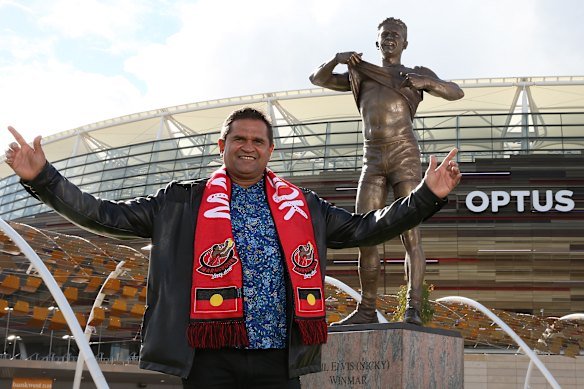 Nicky Winmar poses with his statue during its unveiling in 2019.