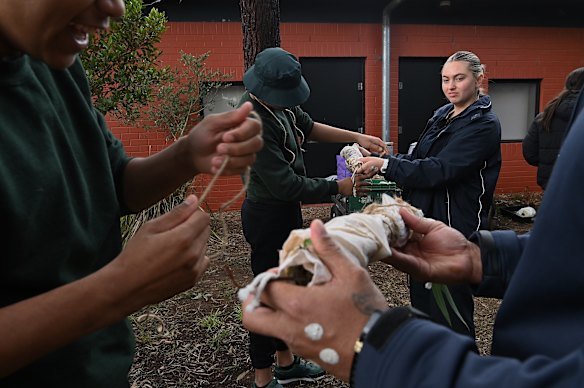 Young people learn traditional dying of material in the learning and yarning circle area at Reiby.