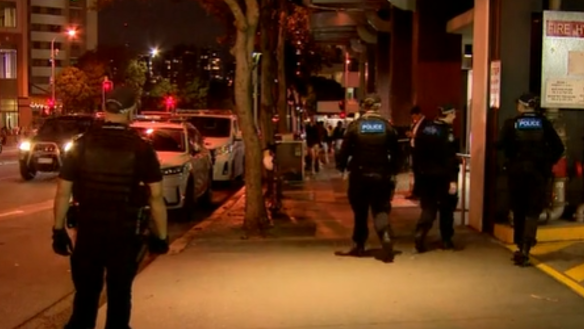 More than a dozen police roamed the city block searching for a man wanted in relation to a hit-and-run.